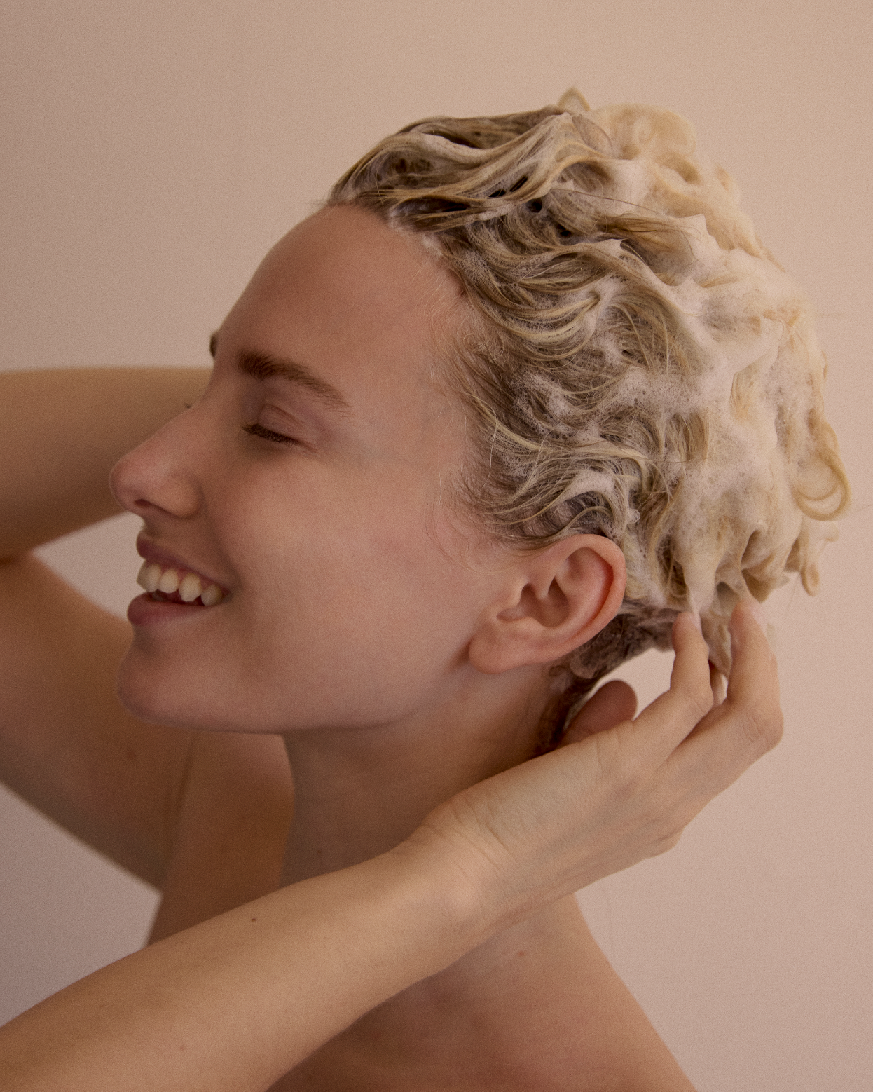 OneWonder hair care — model washing hair with the 6-in-1 shampoo
